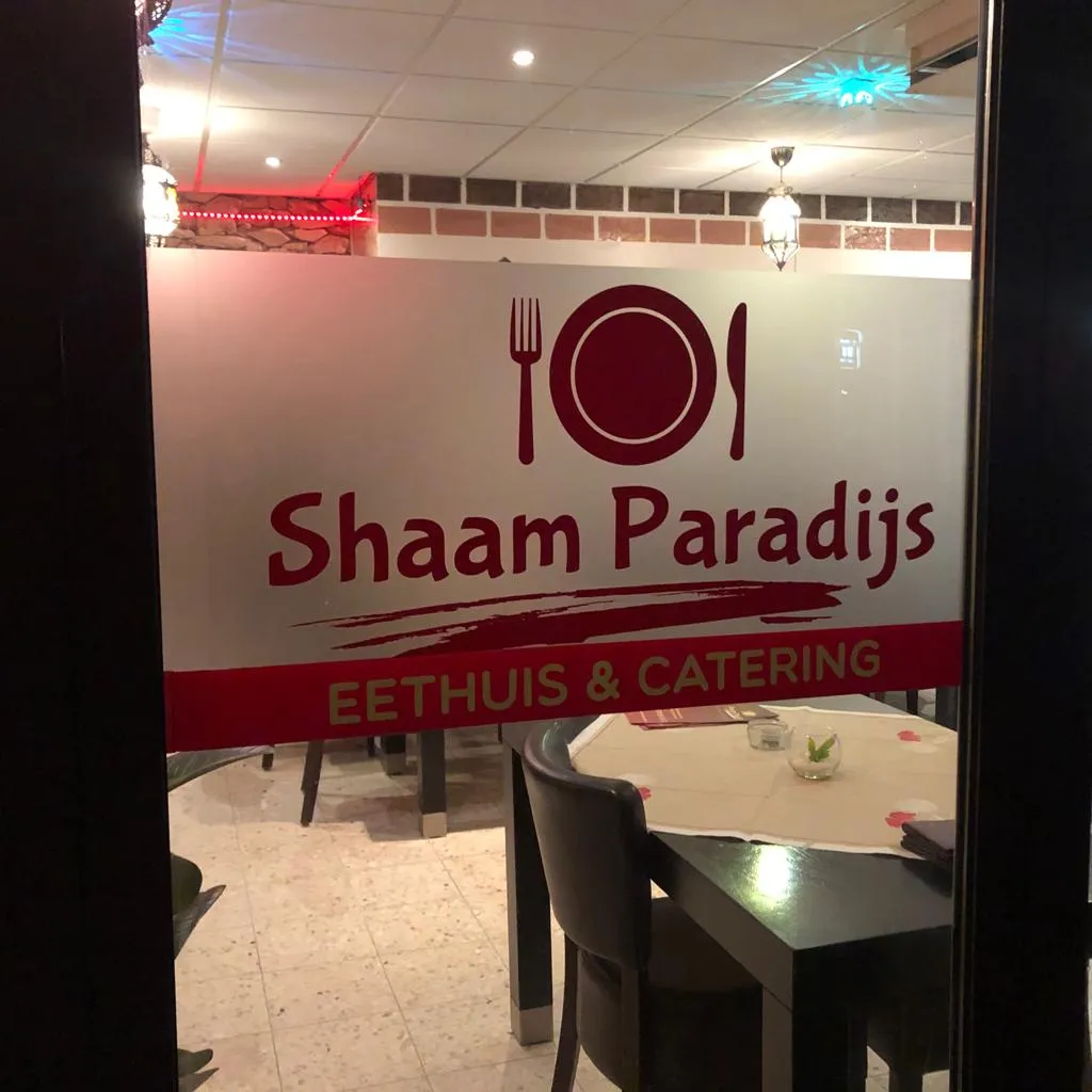 Matte glasfolie met het Shaam Paradijs-logo die de eetzaal van het eethuis afschermt, door ZON Reclame.