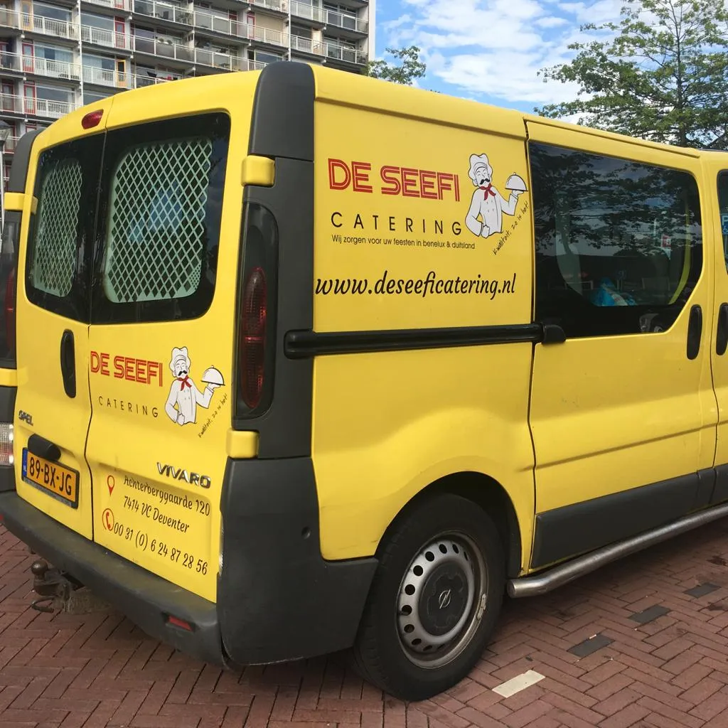 Voertuigbelettering op de gele bedrijfsbus van De Seefi Catering uit Deventer door ZON Reclame.