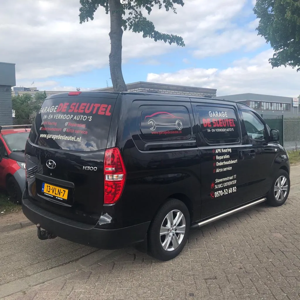 Autobelettering op de bedrijfsbus van Garage De Sleutel uit Deventer door ZON Reclame.