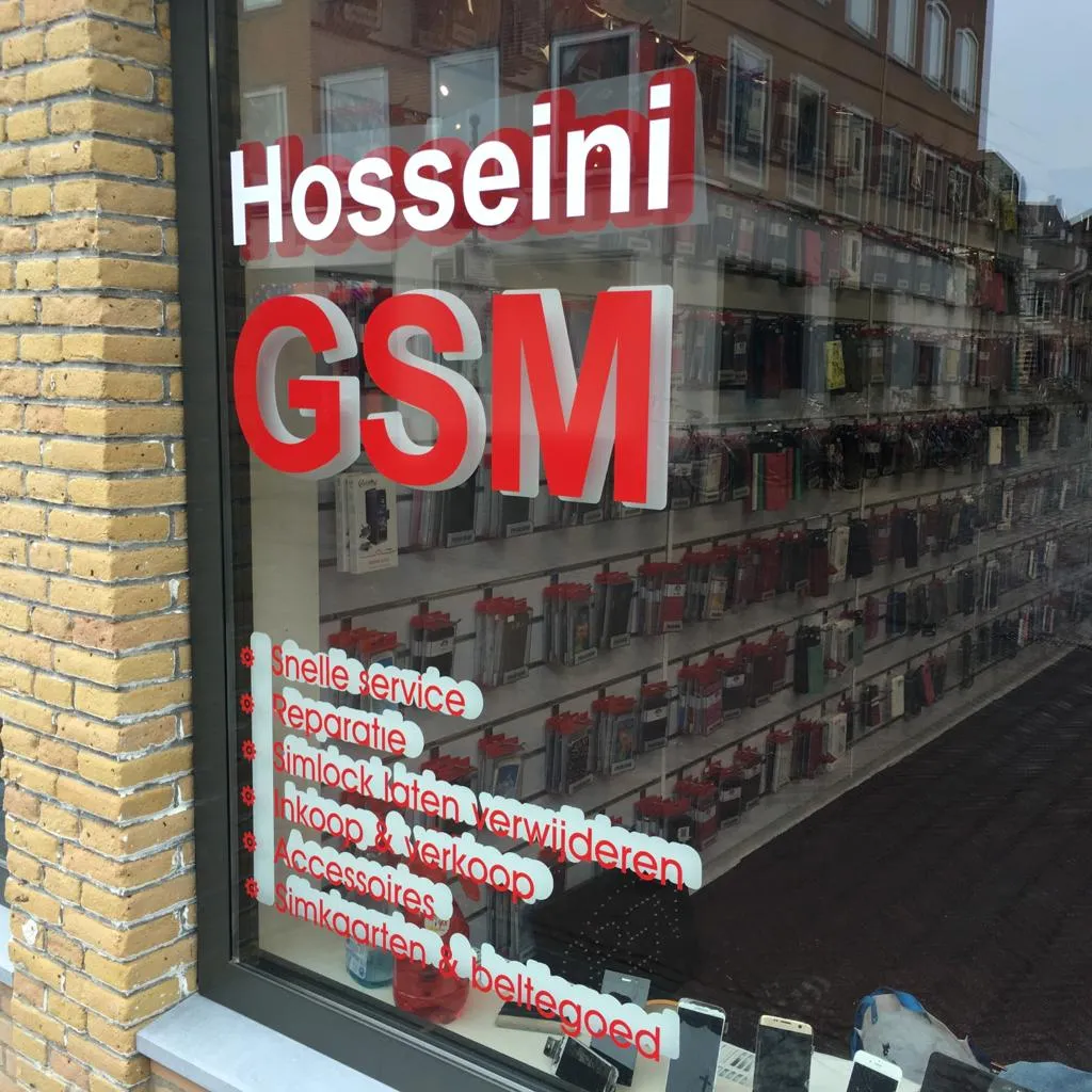 Rood-witte raambelettering met dienstenlijst voor telefoonwinkel Hosseini GSM door ZON Reclame.